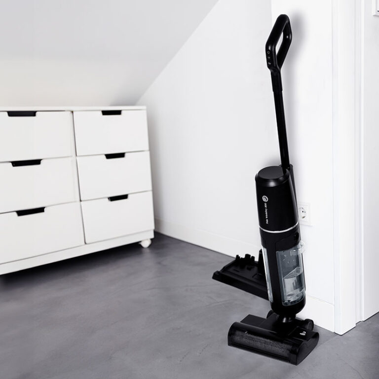 Modern Cordless vacuum cleaner leaning on a wall of a room